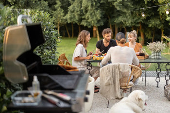 People at a bbq eating food with a dog